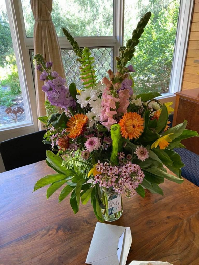 Flowers in a vase with get well card